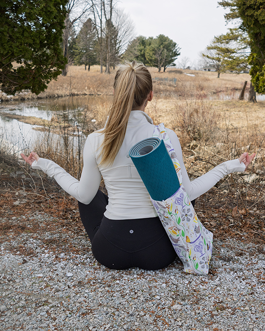 Young lady shown posing with a yoga mat inside a 100% recycled plastic tote bag.