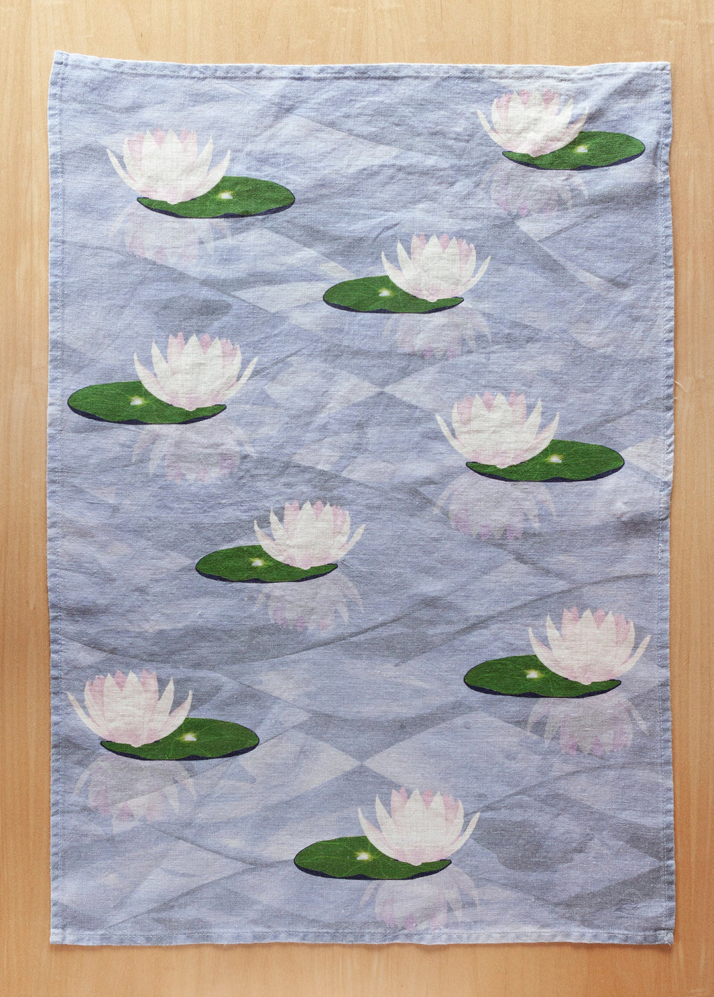 Full tea towel photographed flat. Water lilies and reflective water.